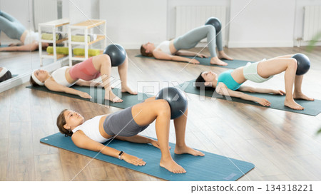 Young girls practicing bridge position with soft ball Young girls practicing bridge position with soft ball 134318221