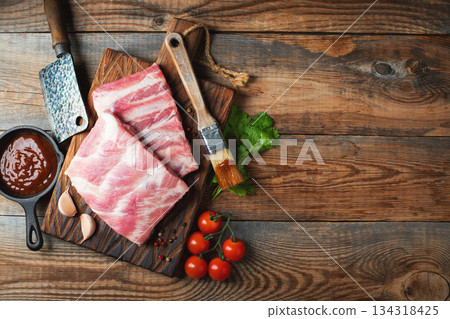 Raw pork ribs with spices, salt and rosemary on dark wooden background 134318425