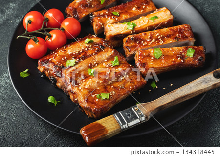 Hot grilled spare ribs from a summer BBQ served on a plate with sauce. Top view. Copy space Hot grilled spare ribs from a summer BBQ served on a plate with sauce. Top view. Copy space 134318445