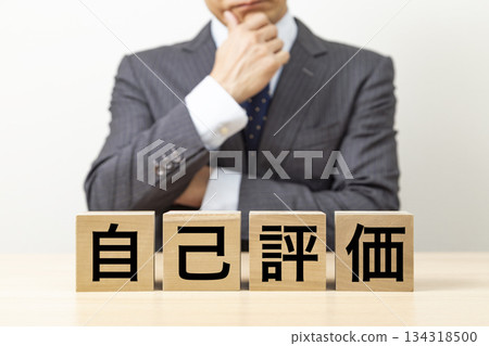 Blocks with the word "Self-Evaluation" written on them and businessmen Blocks with the word "Self-Evaluation" written on them and businessmen 134318500