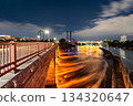 Long exposure captures Stone Arch Bridge over Mississippi River in Minneapolis, USA. Illuminated arches reflect in flowing water under a night sky 134320647