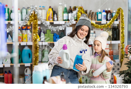 Mother and daughter choose for window cleaning spray and detergent together during Christmas at home improvement store 134320793