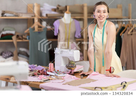 Young woman seamstress invites to sewing workshop Young woman seamstress invites to sewing workshop 134320834