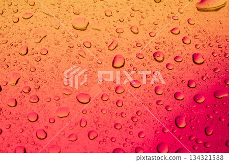 Macro shot of water drops on a window with vibrant magenta and red gradient light. Fresh liquid pattern. Macro shot of water drops on a window with vibrant magenta and red gradient light. Fresh liquid pattern. 134321588