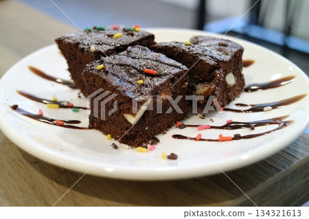 白色盤子上放著撒有糖屑的巧克力布朗尼 134321613