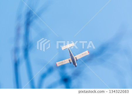 Small ultralight airplane with overhead wing and single propeller flying in sunset sky. Small ultralight airplane with overhead wing and single propeller flying in sunset sky. 134322083
