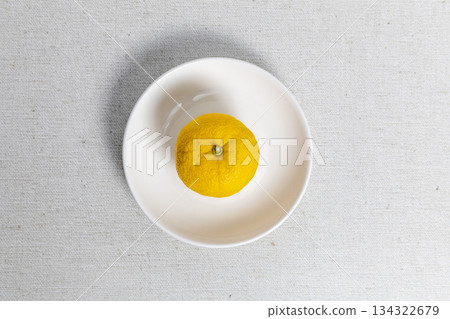 Yuzu placed in the center of a white plate. Winter solstice, citrus fruit, Japanese style image. 134322679