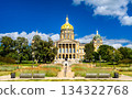 Iowa State Capitol building stands on a hill in Des Moines, USA. Historic architecture features a central golden dome and four corner domes under a blue summer sky 134322768