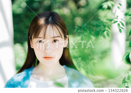 A woman in the sunlight filtering through the trees 134322826