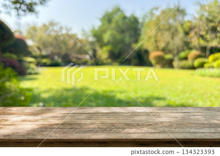 Empty wood table top with abstract blur park garden background 134323393
