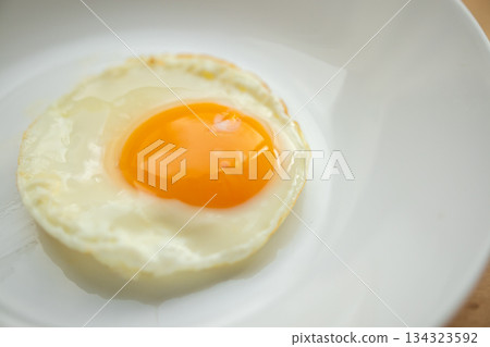 Fried egg on white dish close up Fried egg on white dish close up 134323592