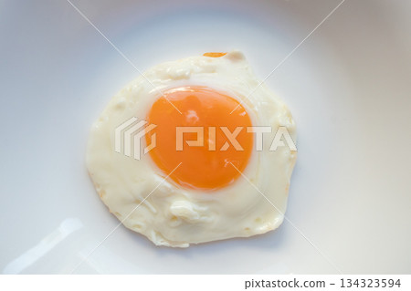 Fried egg on white dish close up Fried egg on white dish close up 134323594