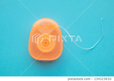 dental floss in case on blue background dental floss in case on blue background 134323610