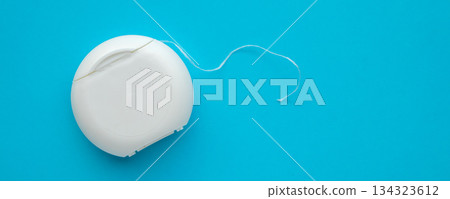 dental floss in case on blue background dental floss in case on blue background 134323612
