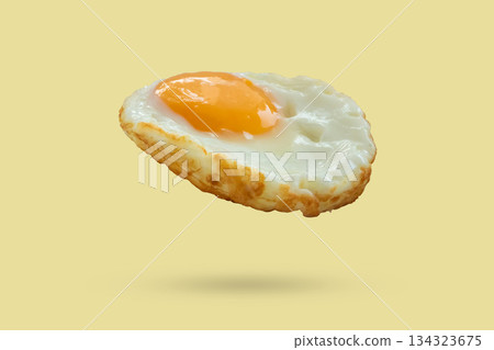 Fried egg float on yellow background 134323675