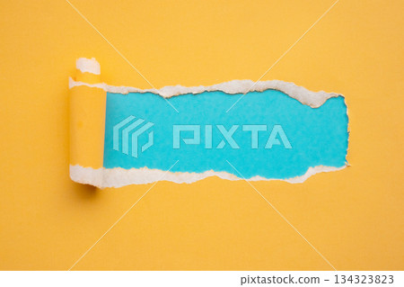 Yellow torn paper rolled edge with space on blue background Yellow torn paper rolled edge with space on blue background 134323823