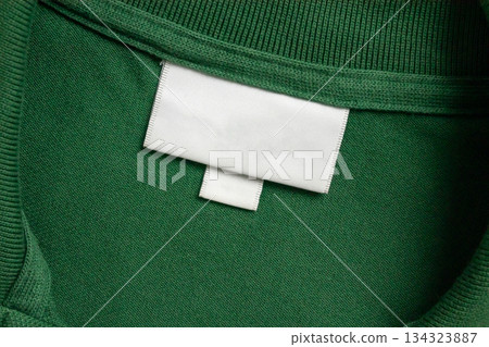 Blank white laundry care clothes label on green shirt fabric texture background 134323887