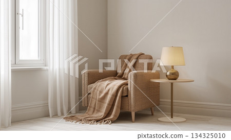 A chair with a blanket draped over it sits in front of a window 134325010