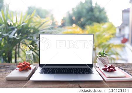 Laptop and gift box arranged on wood desk, with balcony view Laptop and gift box arranged on wood desk, with balcony view 134325334