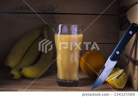 Multivitamin juice with fruits. Citrus juice. Juice from bananas and oranges. Knife and fruits. Multivitamin juice with fruits. Citrus juice. Juice from bananas and oranges. Knife and fruits. 134325569