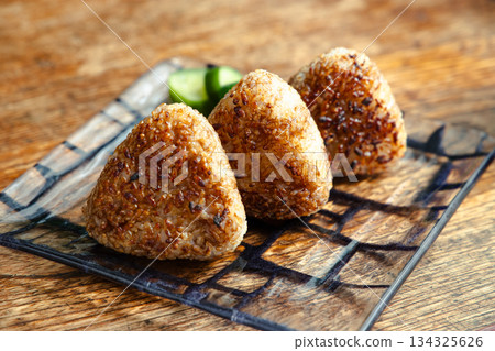 Grilled rice balls cooked over an open flame with a fragrant burnt finish 134325626