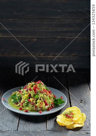 Salad decorated with pomegranate berries. Salads with pomegranate and chips. 134325659