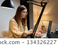 Woman working at desk with laptop in home office 134326227