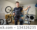 Handyman holding drill standing on ladder in utility room 134326235