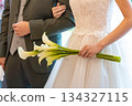 Bride holding lilies at wedding ceremony 134327115