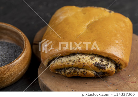 fresh wheat bun with lots of poppy seeds, soft bun with poppy seeds on the table fresh wheat bun with lots of poppy seeds, soft bun with poppy seeds on the table 134327300
