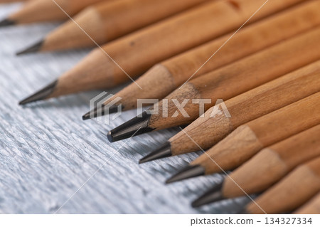 pencils with black lead on blue paper, several monochrome pencils for sketches or graphic work are in a row. 134327334