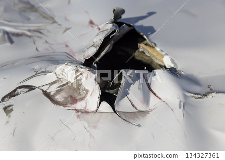 a part of a car damaged during an accident, a white-painted car body damaged by another car 134327361