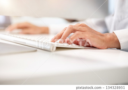 Close up of asian businessman's hands typing on keyboard at computer table in the company's office. 134328931