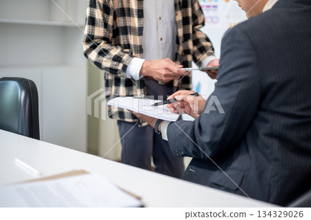 Close up of a man explaining document to businessman boss during work presentation in company office 134329026