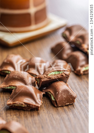 Chocolate bar with pistachios cream on wooden table. 134329585