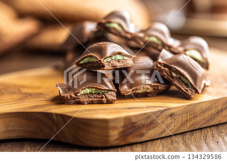 Chocolate bar with pistachios cream on wooden table. Chocolate bar with pistachios cream on wooden table. 134329586