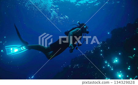 Scuba Diver Exploring a Dark Underwater Cave or Reef with Glowing Bioluminescent Lights 134329828