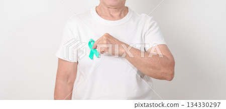 Elderly with Teal Ribbon for September Ovarian Cancer Awareness month, PCOS, January Cervical Cancer, April Sexual Assault, June PSTD, Post Traumatic Stress Disorder, May Tourette syndrome Elderly with Teal Ribbon for September Ovarian Cancer Awareness month, PCOS, January Cervical Cancer, April Sexual Assault, June PSTD, Post Traumatic Stress Disorder, May Tourette syndrome 134330297