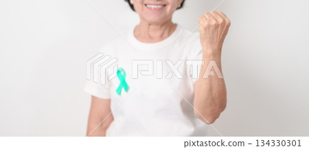 Elderly with Teal Ribbon for September Ovarian Cancer Awareness month, PCOS, January Cervical Cancer, April Sexual Assault, June PSTD, Post Traumatic Stress Disorder, May Tourette syndrome Elderly with Teal Ribbon for September Ovarian Cancer Awareness month, PCOS, January Cervical Cancer, April Sexual Assault, June PSTD, Post Traumatic Stress Disorder, May Tourette syndrome 134330301