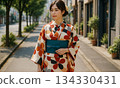 一位年輕女子身著現代和服漫步街頭。這種和服融合了日式和西式風格。 134330431