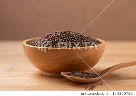 Dried perilla seed in a bowl with spoon on wooden background Dried perilla seed in a bowl with spoon on wooden background 134330726