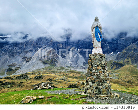 Blessed virgin Mary statue at Cirque de Troumouse, Heas in France. Meadows surrounded by dramatic mountain peaks Blessed virgin Mary statue at Cirque de Troumouse, Heas in France. Meadows surrounded by dramatic mountain peaks 134330919