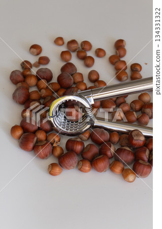 Nutcracker lying on the background of hazelnuts Nutcracker lying on the background of hazelnuts 134331322