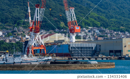 Shipbuilding cranes line the shipyard at Kure Port in Hiroshima Prefecture 134331406