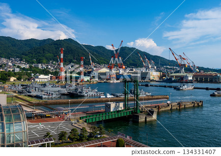 這是廣島縣吳港海軍港口的景象，自衛隊的船艇和工作船停泊在那裡。 134331407