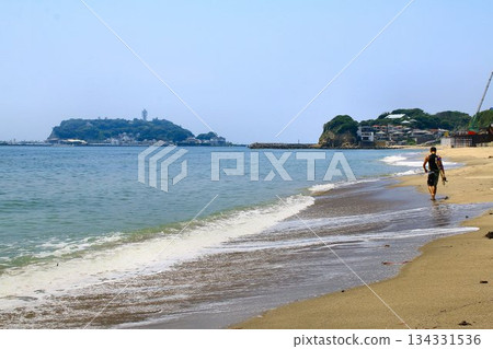 一位衝浪者走在俯瞰江之島的海灘上 134331536