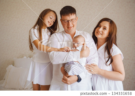 Family celebrating joy with their newborn in cozy room 134331658