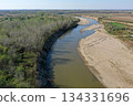 Flying over a river flowing on a plain aerial view 134331696