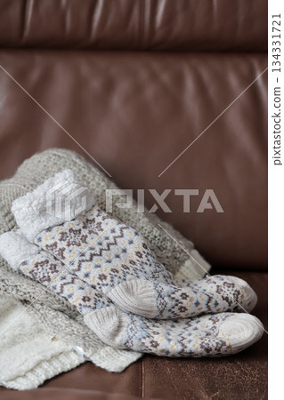 沙發上放著毯子和暖和的襪子。 134331721