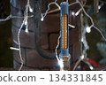 Outdoor thermometer shows freezing temperatures amidst festive holiday lights and pipes 134331845